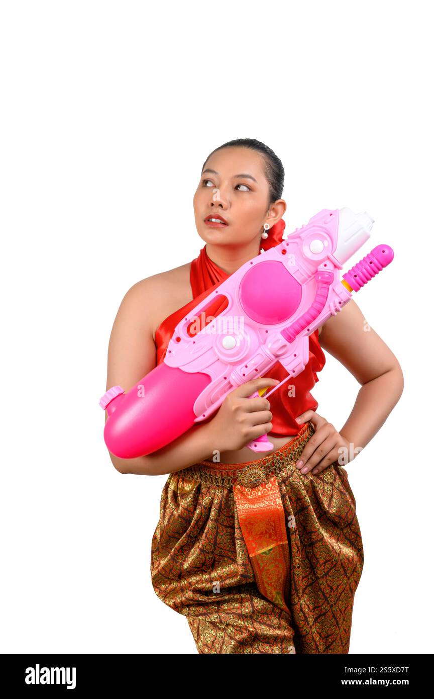 Porträt schöne Frau im Songkran Festival mit traditioneller thailändischer Tracht stehend und mit Wasserpistole mit Lächeln und Kamera auf weiß Stockfoto
