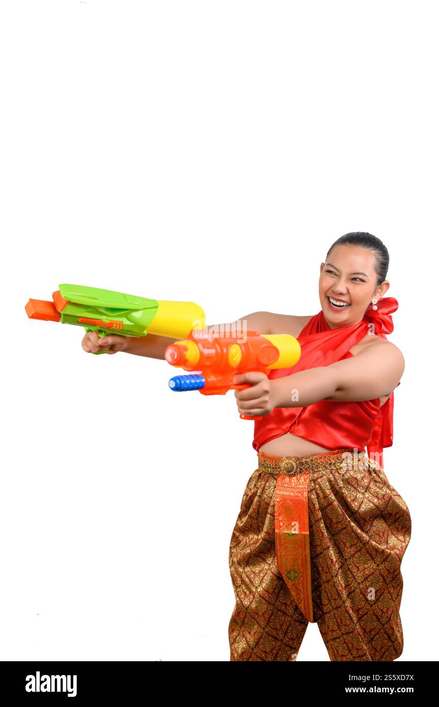 Porträt schöne Frau im Songkran Festival mit traditioneller thailändischer Tracht stehend und hält zwei Wasserpistolen mit einem Lächeln auf weißem Hintergrund. Stockfoto
