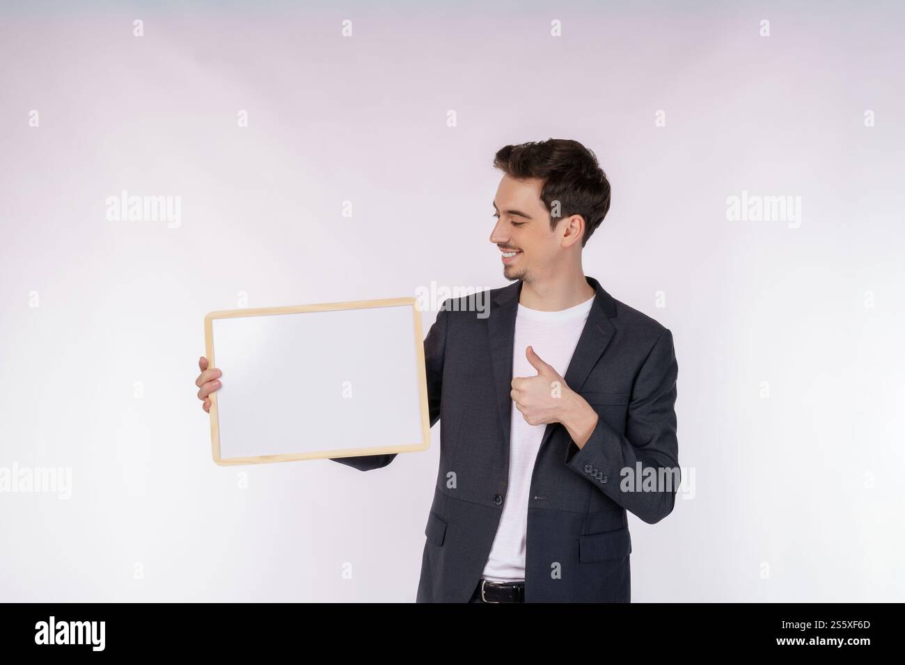 Porträt eines glücklichen Geschäftsmannes mit leerem Schild auf isoliertem weißem Hintergrund. Leerer Kopierbereich für Slogan oder Werbetext. Stockfoto