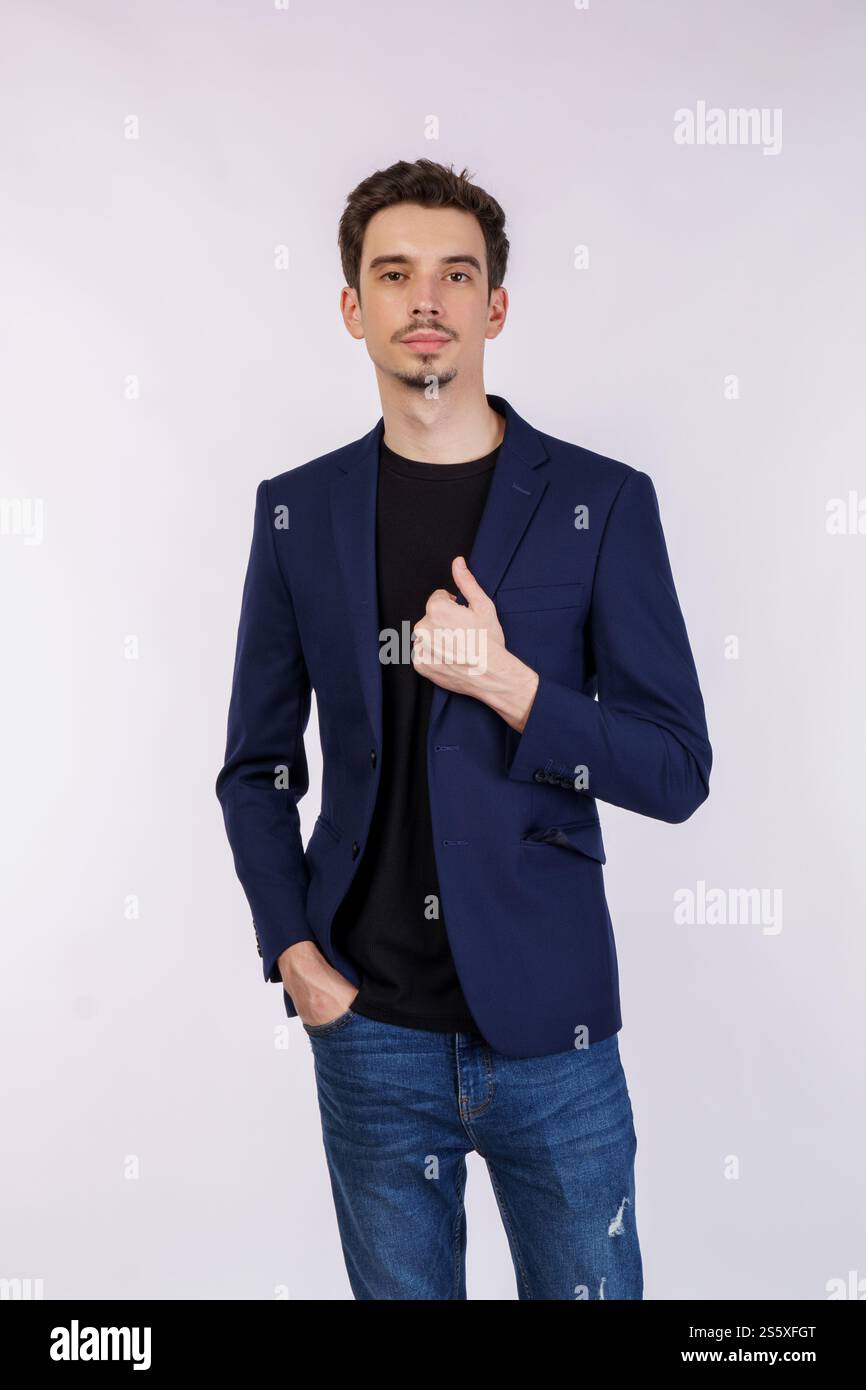 Porträt eines glücklichen, gutaussehenden jungen Mannes im Anzug, der auf isoliertem Hintergrund posiert. Stockfoto