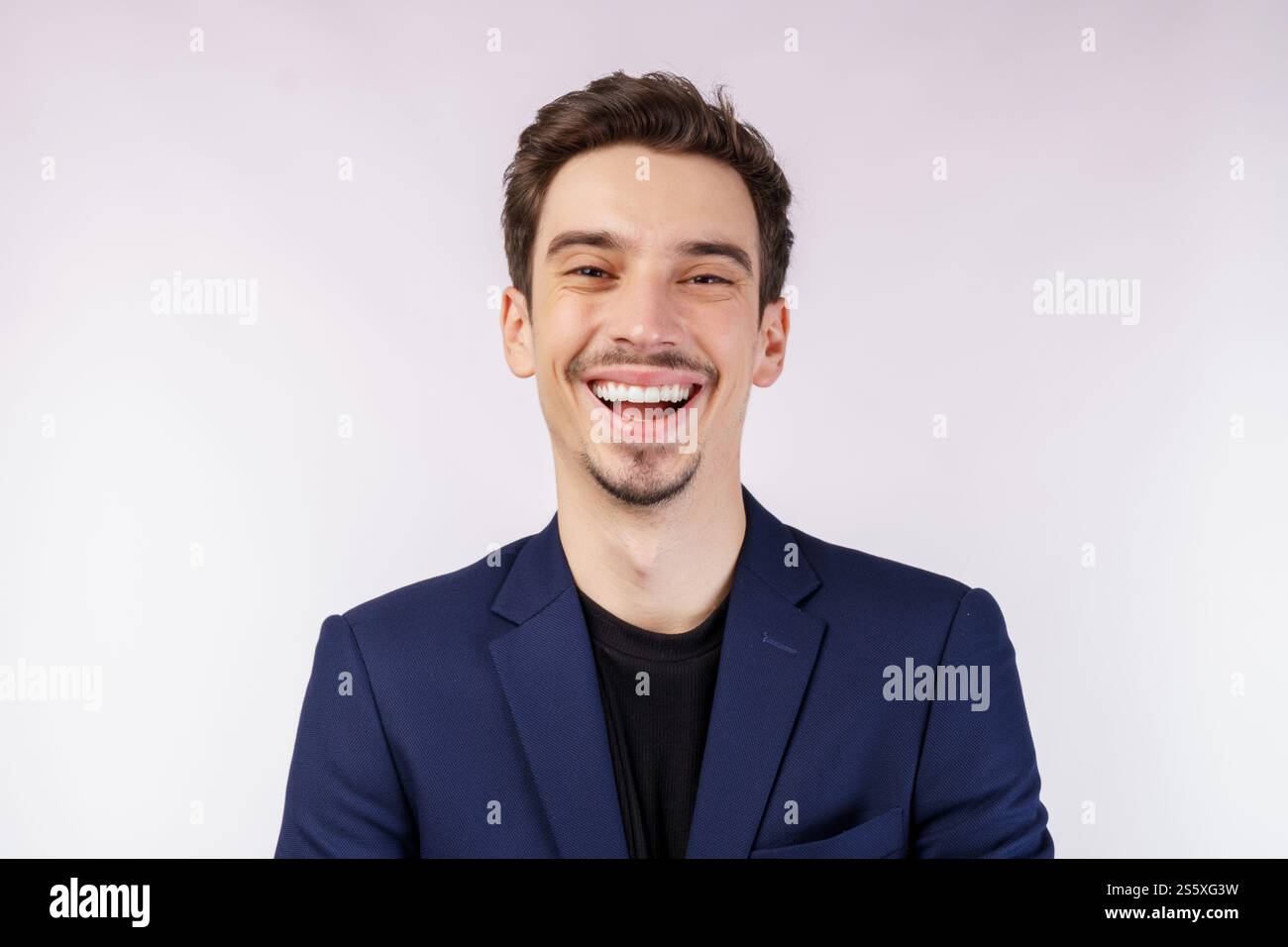 Porträt eines fröhlichen Geschäftsmannes, der lächelt und die Kamera über weißem Hintergrund betrachtet. Finanz-, Investitions- und Sparkonzept. Stockfoto