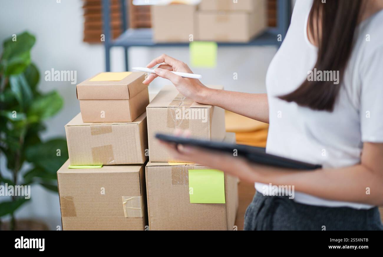 Asiatische Frau, die Paketzustellbox vorbereitet Versand für den Einkauf Online-Zustellung Postservice Menschen und Versandkonzept. Stockfoto