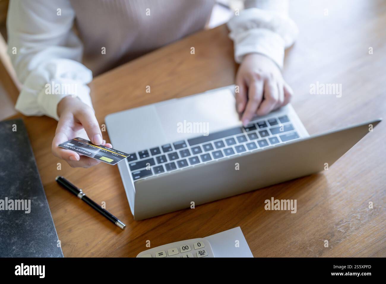 Frau, die auf einem Laptop mit Kreditkarte für Internet Online-E-Commerce-Einkaufen Geld ausgeben Online-Einkaufen Handy-Laptop-Technologie Stockfoto