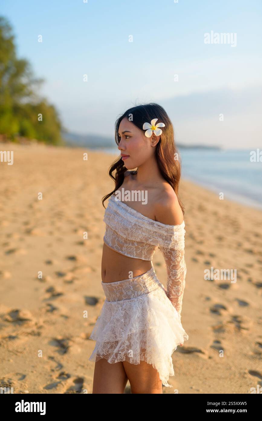 Golden Hour Beauty Konzept Asiatische Frau genießt friedlichen Sonnenuntergang am Strand Stockfoto