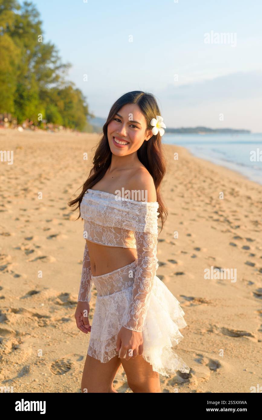 Golden Hour Beauty Konzept Asiatische Frau genießt friedlichen Sonnenuntergang am Strand Stockfoto