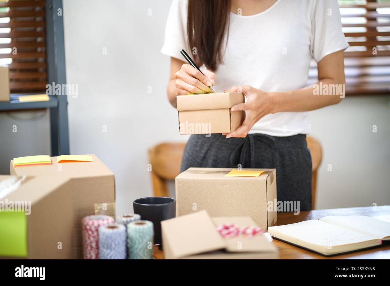 Asiatische Frau, die Paketzustellbox vorbereitet Versand für den Einkauf Online-Zustellung Postservice Menschen und Versandkonzept. Stockfoto
