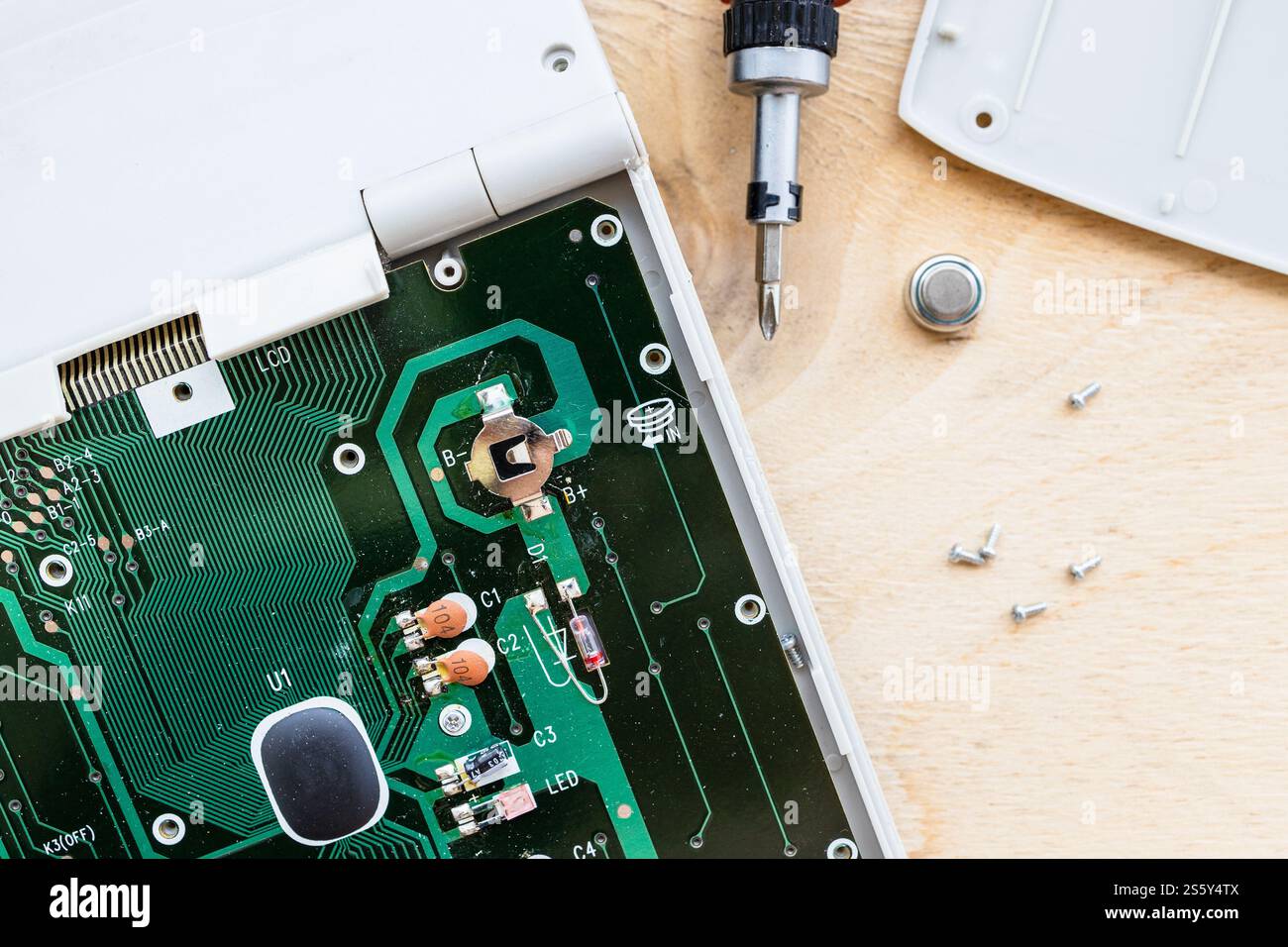 Batteriewechsel in der Leiterplatte des zerlegten Buchhaltungsrechners Nahaufnahme Stockfoto