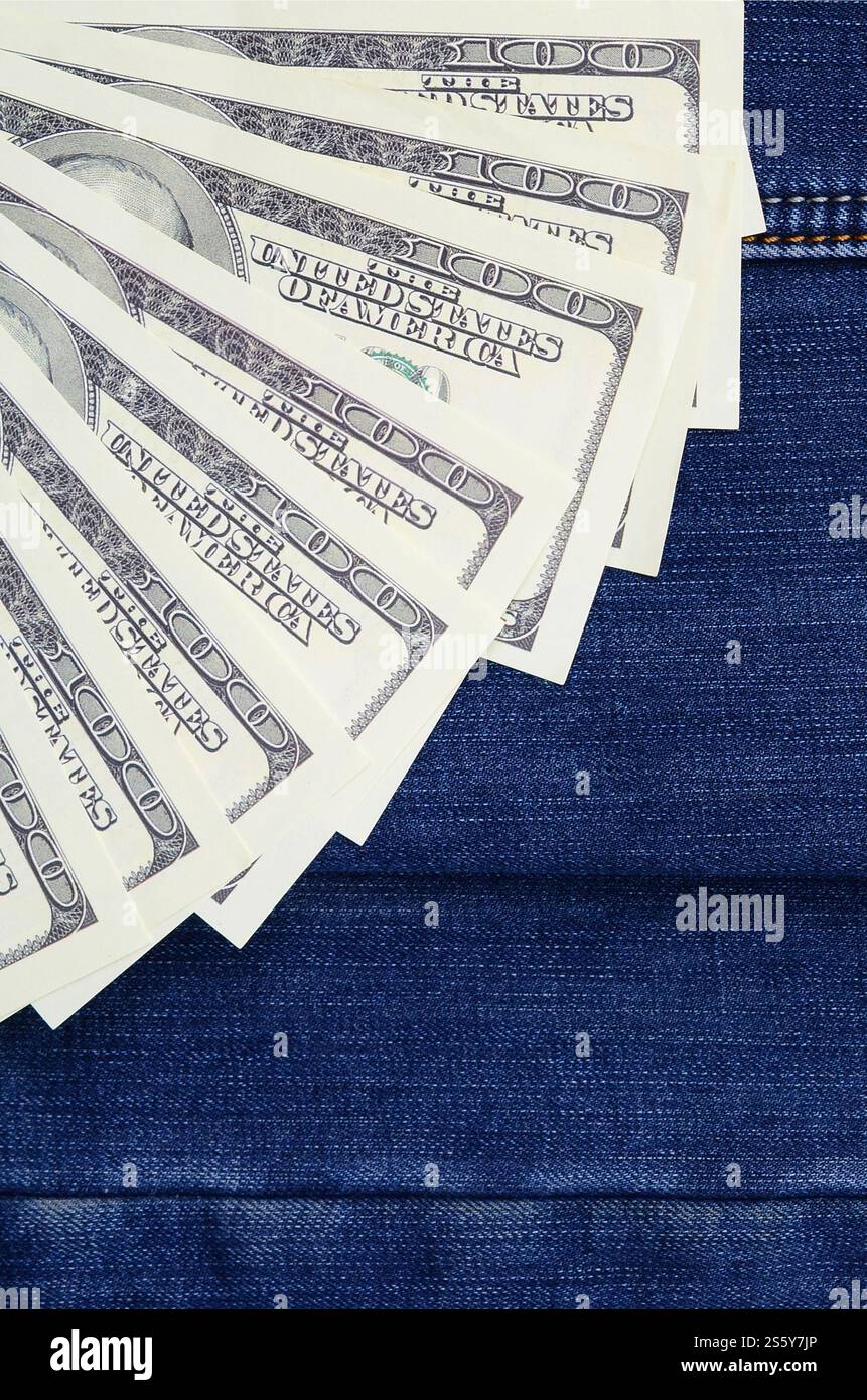 Der Fan einer Menge US-Dollar ist auf einer dunklen Jeansfläche. Hintergrundbild Stockfoto