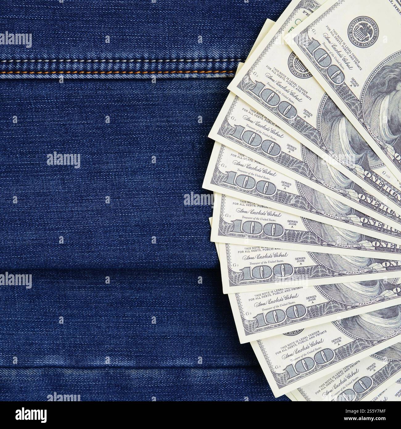 Der Fan einer Menge US-Dollar ist auf einer dunklen Jeansfläche. Hintergrundbild Stockfoto