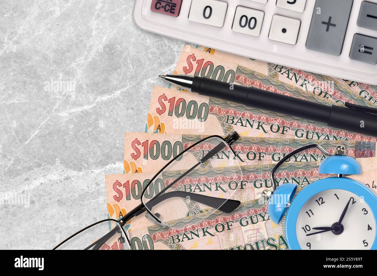 1000 Guyana-Dollar-Scheine und Taschenrechner mit Brille und Stift. Geschäftsdarlehen oder Steuerzahlung Saisonkonzept. Finanzplanung und Zahlungszeit Stockfoto