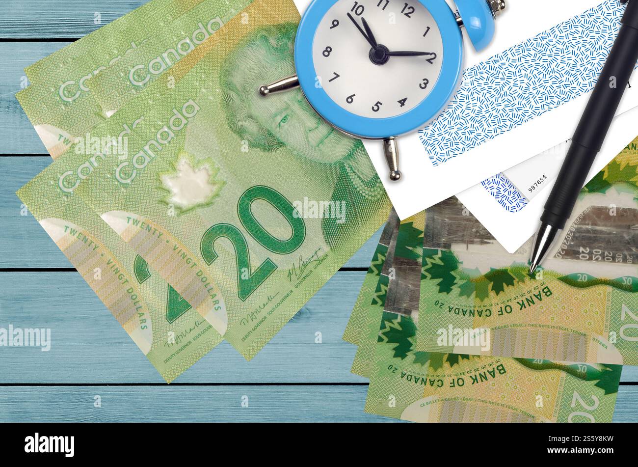 20 kanadische Dollar Rechnungen und Wecker mit Stift und Umschläge. Tax Saison Konzept, Zahlungsfrist für Kredit oder Darlehen. Finanzoperationen mit Stockfoto