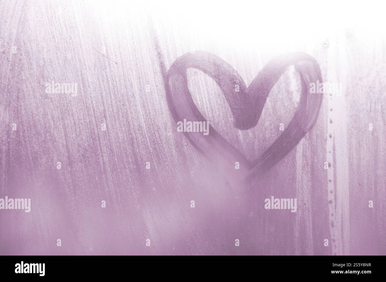 Eine herzförmige Zeichnung durch einen Finger auf einen Beschlagenen Glas im regnerischen Wetter gezeichnet Stockfoto