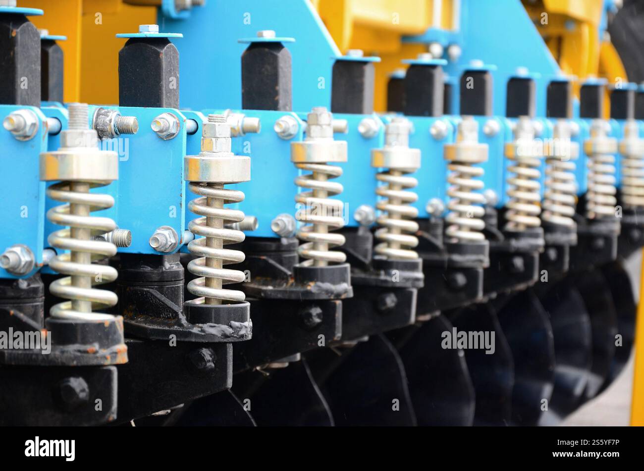 Federsystem der landwirtschaftlichen Sämaschine Nahaufnahme. Federsystem der landwirtschaftlichen Sämaschine im Außenbereich Stockfoto