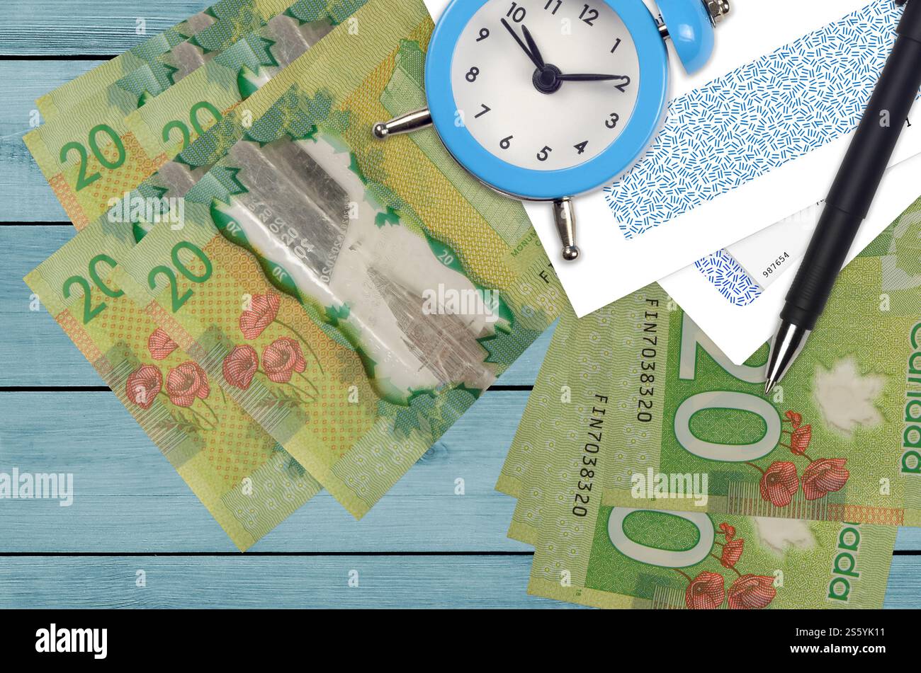 20 kanadische Dollar Rechnungen und Wecker mit Stift und Umschläge. Tax Saison Konzept, Zahlungsfrist für Kredit oder Darlehen. Finanzoperationen mit Stockfoto