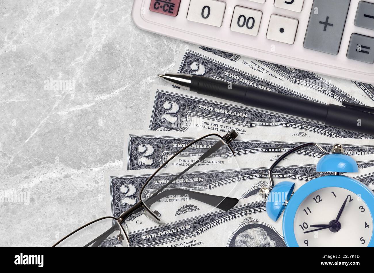2 US-Dollar-Scheine und Taschenrechner mit Brille und Stift. Geschäftsdarlehen oder Steuerzahlung Saisonkonzept. Finanzplanung und Zeit für die Zahlung von Steuern. 2 USA Stockfoto