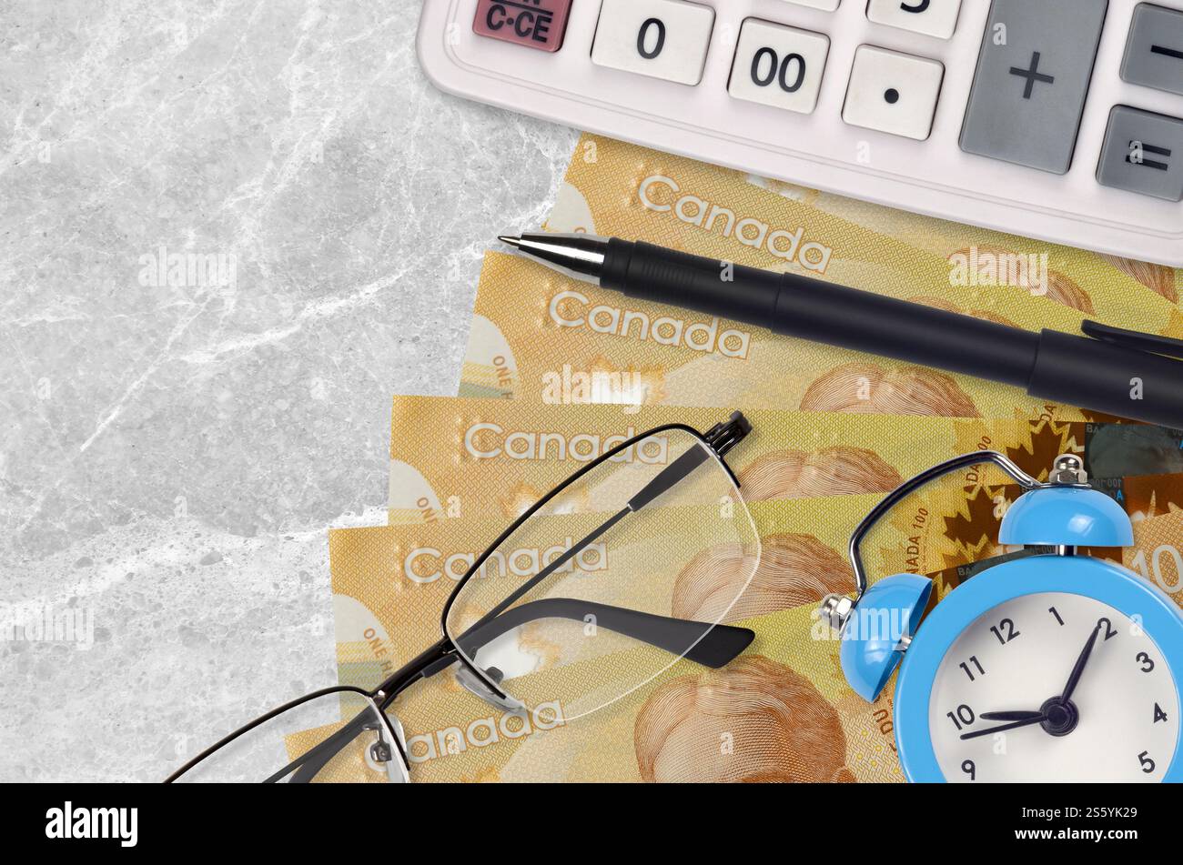 100 kanadische Dollarscheine und Taschenrechner mit Brille und Stift. Geschäftsdarlehen oder Steuerzahlung Saisonkonzept. Finanzplanung und Zahlungszeit Stockfoto