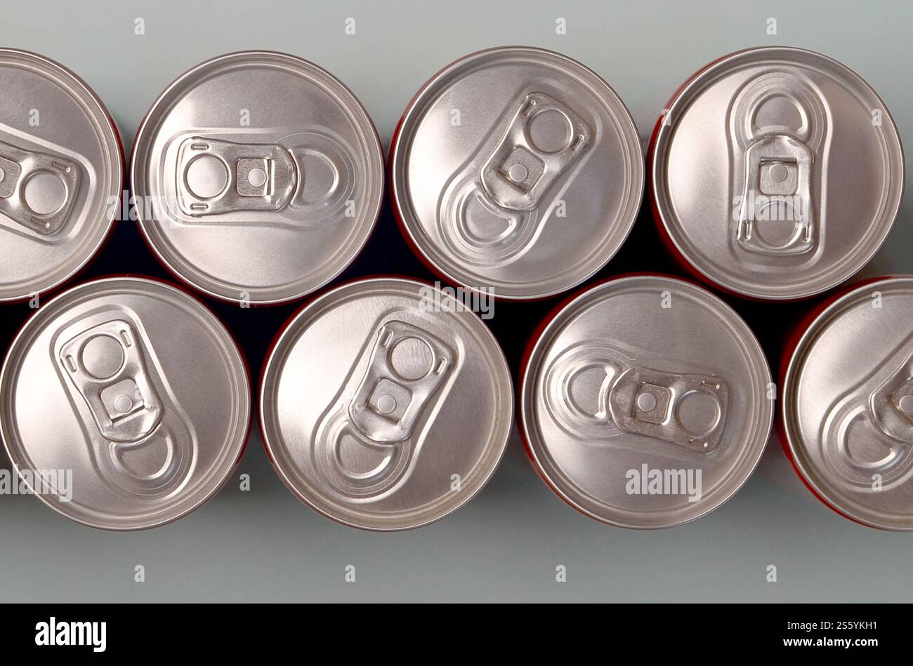 Viele neue Aluminiumdosen mit alkoholfreien Limonaden, Limonade Cola, Bier oder Energy Drink. Konzept der Getränkeherstellung und Massenproduktion. Viele Stockfoto