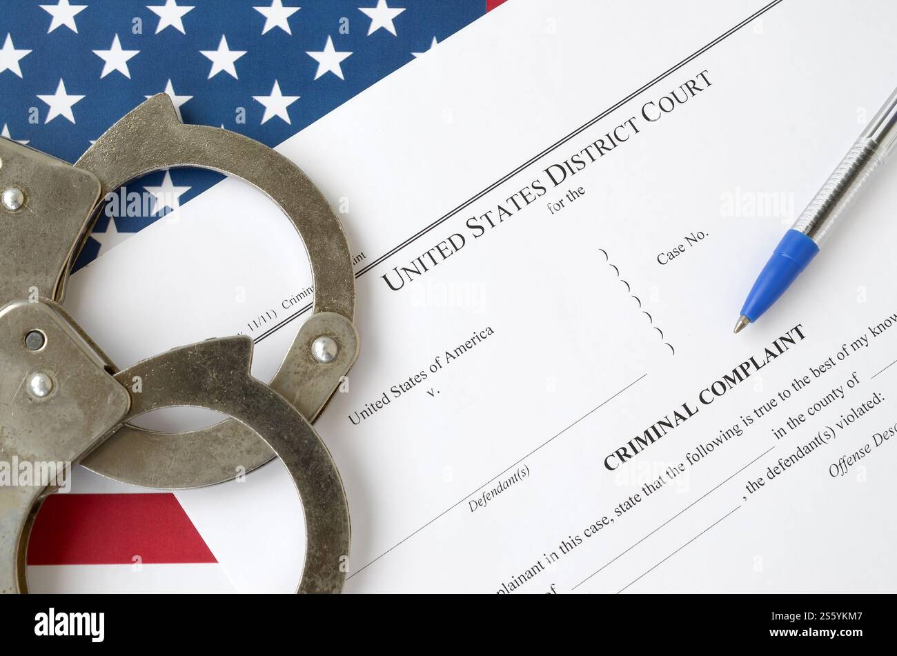 Bezirksgericht Strafanzeige Gerichtspapiere mit Handschellen und blauem Stift auf US-Flagge Nahaufnahme. Bezirksgericht Strafanzeige Gericht Stockfoto