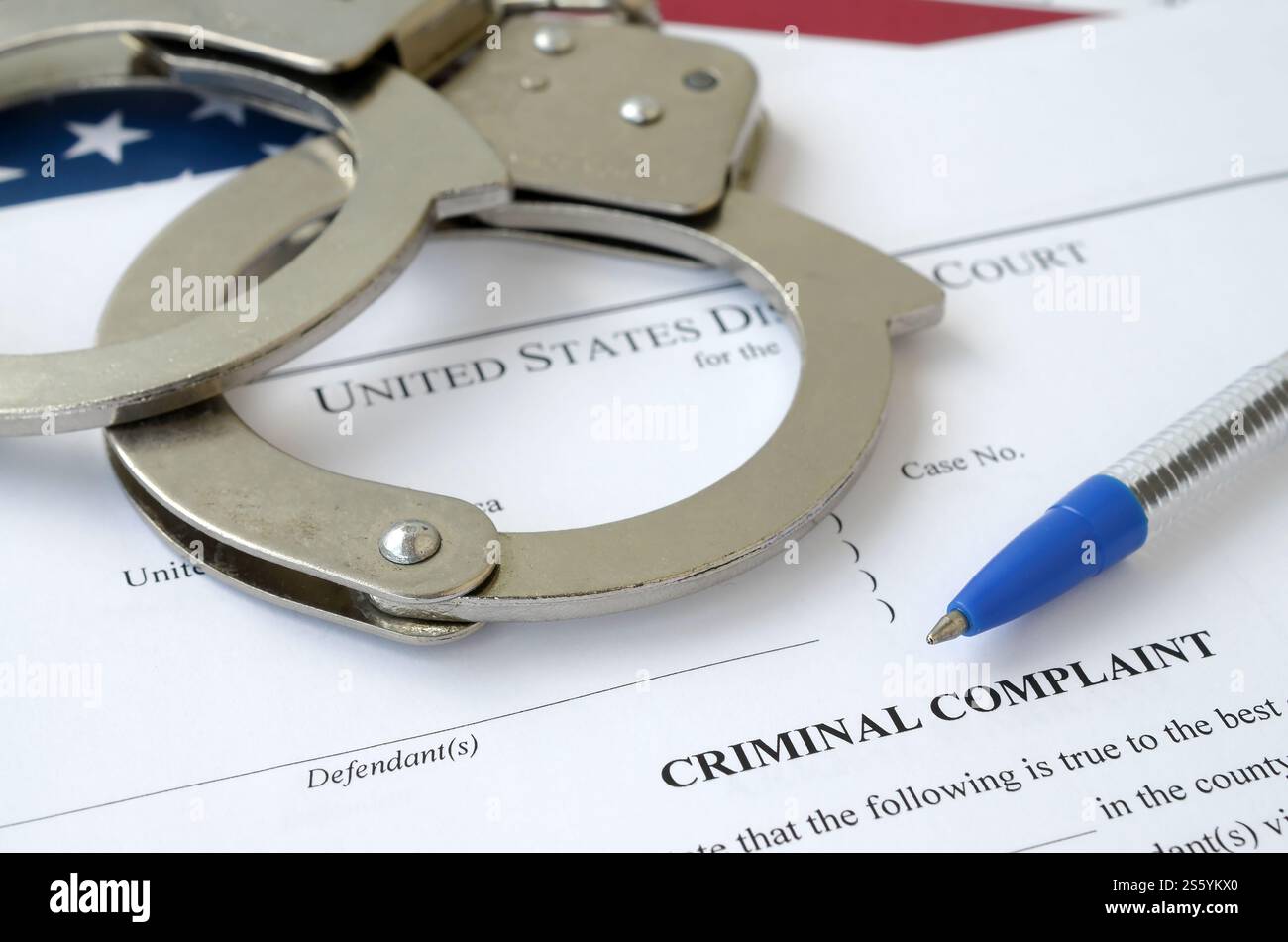 Bezirksgericht Strafanzeige Gerichtspapiere mit Handschellen und blauem Stift auf US-Flagge Nahaufnahme. Bezirksgericht Strafanzeige Gericht Stockfoto