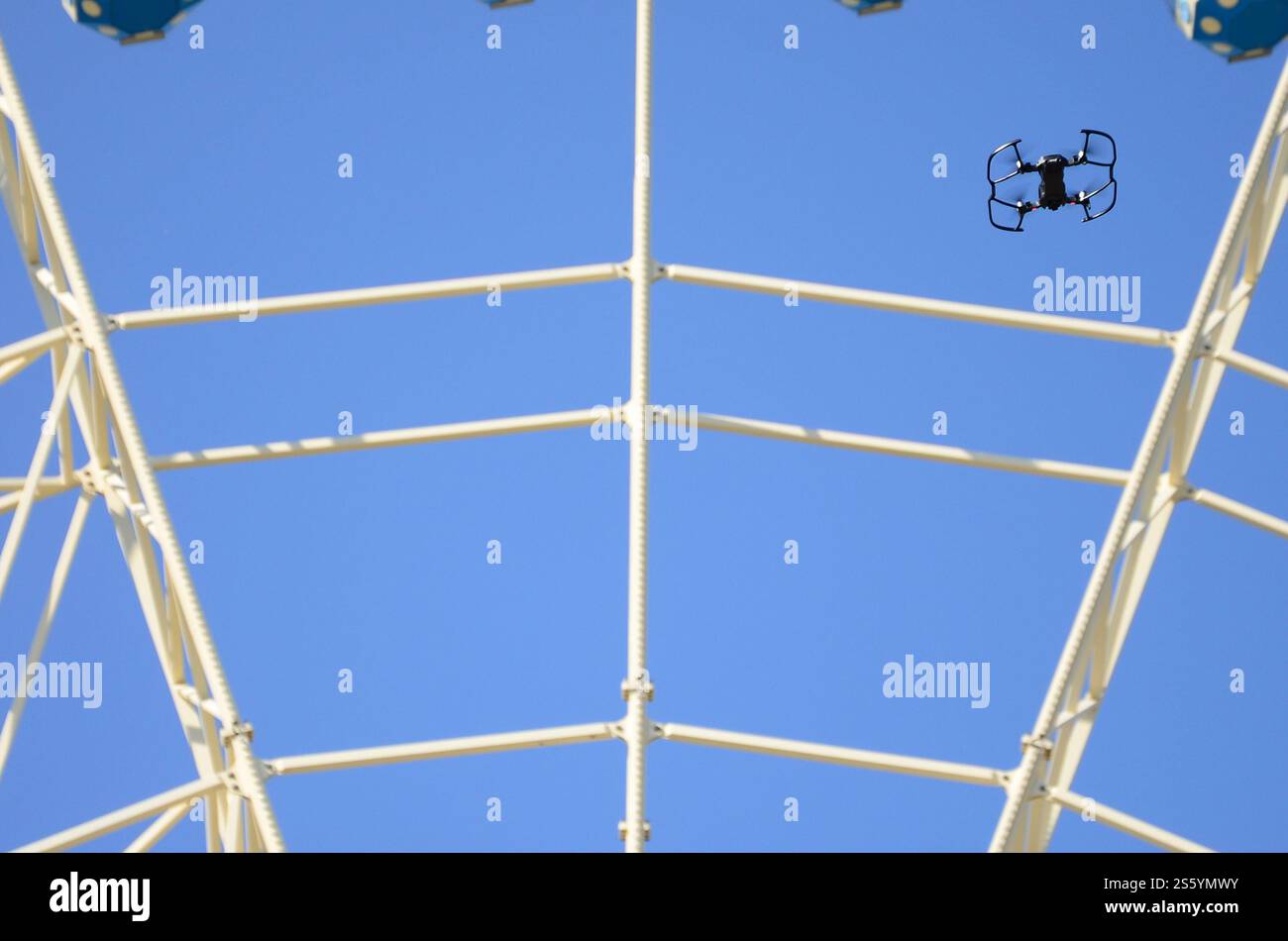 Drohne mit Fotokamera startet vom Land und fliegt für Fotos vor dem Riesenrad. Die Drohne startet vom Land und fliegt, um Fotos zu machen Stockfoto
