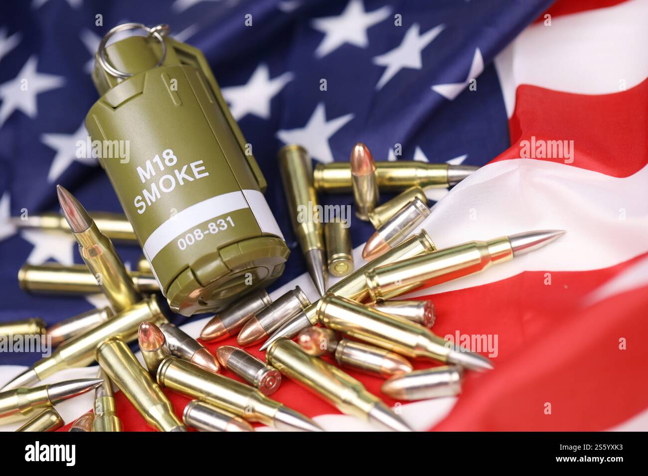 M18 Rauchgranate und viele gelbe Kugeln und Patronen auf US-Flagge. Konzept des Waffenhandels auf US-Territorium oder Sondereinsätzen. Stockfoto