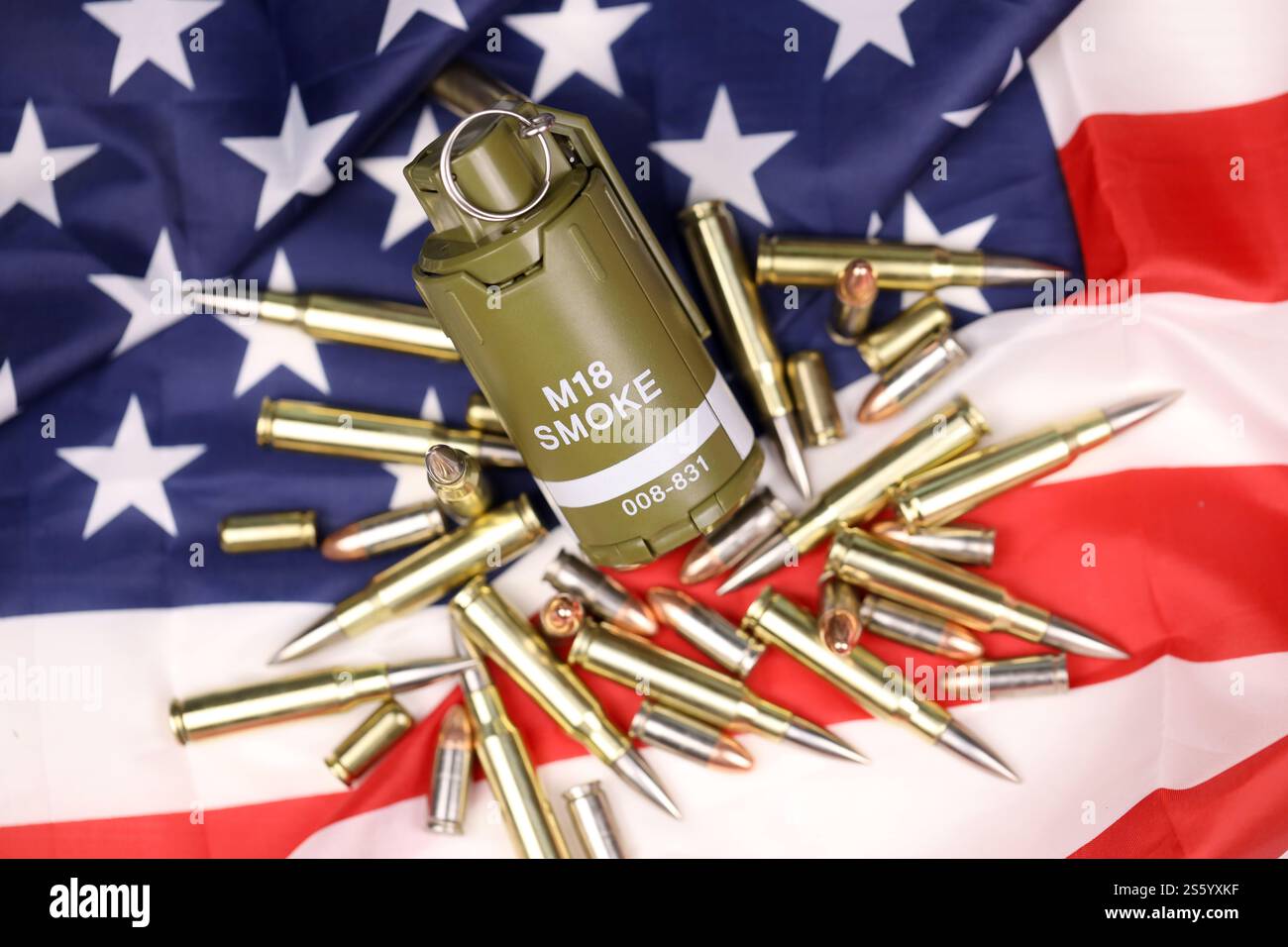 M18 Rauchgranate und viele gelbe Kugeln und Patronen auf US-Flagge. Konzept des Waffenhandels auf US-Territorium oder Sondereinsätzen. Stockfoto