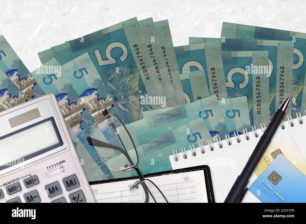 5 kanadische Dollarscheine und Taschenrechner mit Brille und Stift. Steuerzahlungssaisonkonzept oder Investitionslösungen. Finanzplanung oder Buchhalter Stockfoto