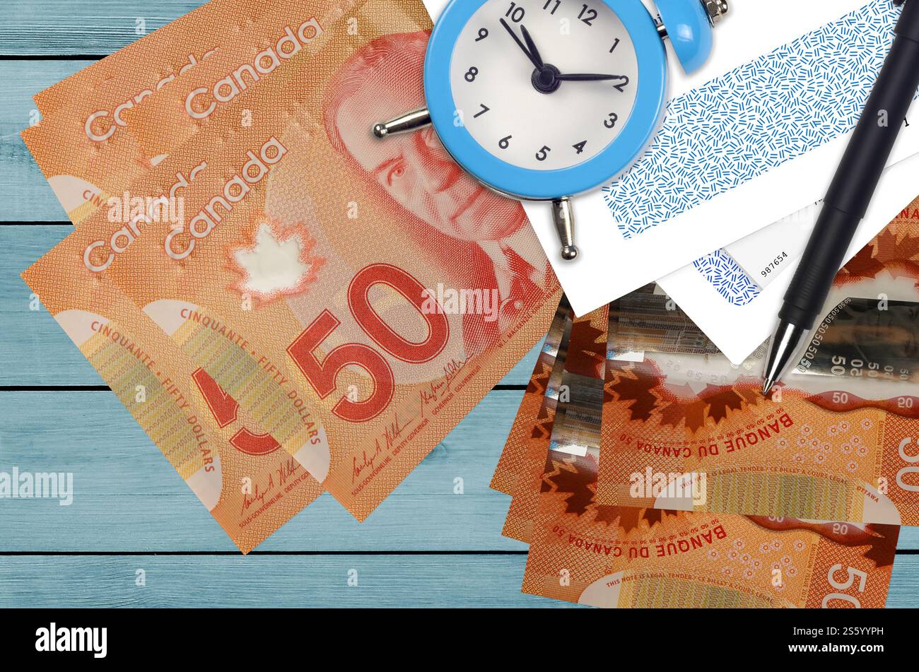 50 kanadische Dollar Rechnungen und Wecker mit Stift und Umschläge. Tax Saison Konzept, Zahlungsfrist für Kredit oder Darlehen. Finanzoperationen mit Stockfoto