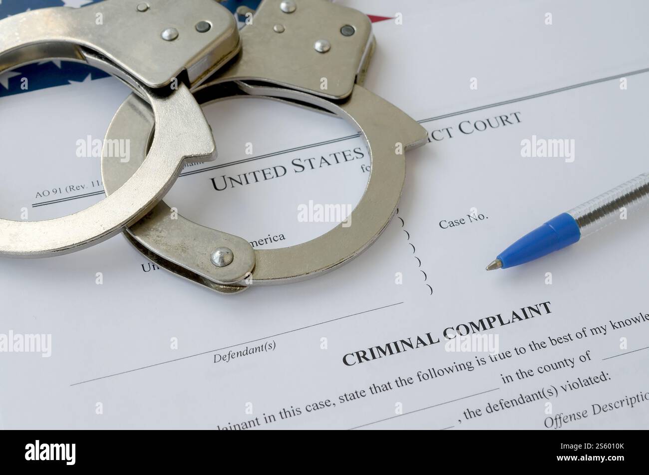 Bezirksgericht Strafanzeige Gerichtspapiere mit Handschellen und blauem Stift auf US-Flagge Nahaufnahme. Bezirksgericht Strafanzeige Gericht Stockfoto