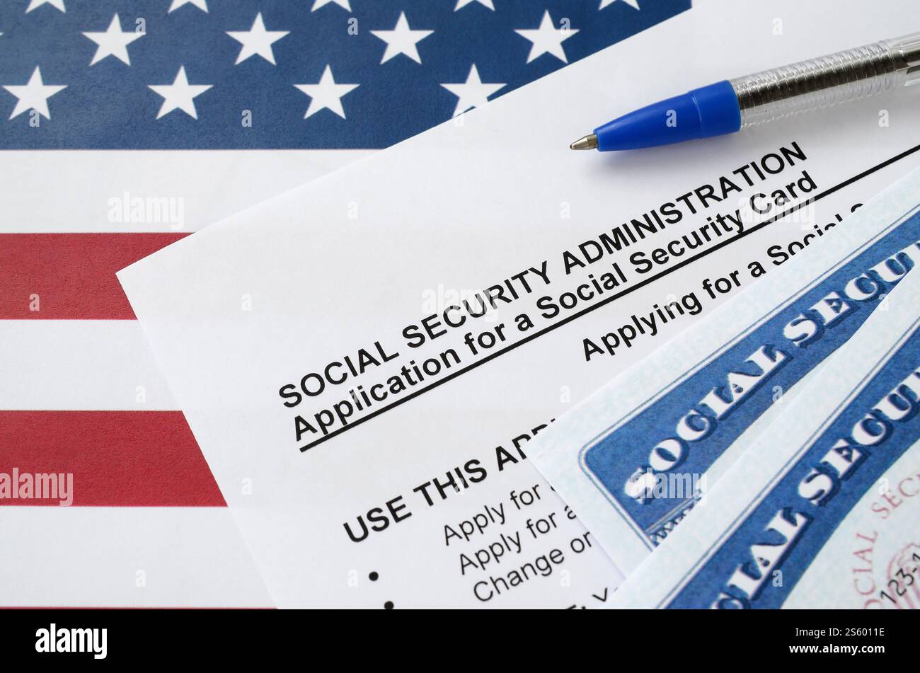 US-amerikanische Sozialversicherungsnummernkarten liegen auf Antrag der Sozialversicherungsverwaltung mit blauem Stift auf US-Flagge Nahaufnahme. Usa Stockfoto US-amerikanische Sozialversicherungsnummernkarten liegen auf Antrag der Sozialversicherungsverwaltung mit blauem Stift auf US-Flagge Nahaufnahme. Usa Stockfoto