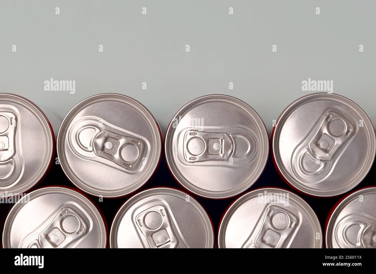 Viele neue Aluminiumdosen mit alkoholfreien Limonaden, Limonade Cola, Bier oder Energy Drink. Konzept der Getränkeherstellung und Massenproduktion. Viele Stockfoto