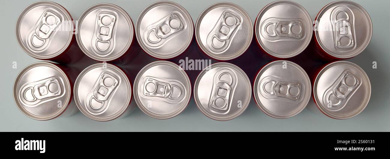 Viele neue Aluminiumdosen mit alkoholfreien Limonaden, Limonade Cola, Bier oder Energy Drink. Konzept der Getränkeherstellung und Massenproduktion. Viele Stockfoto