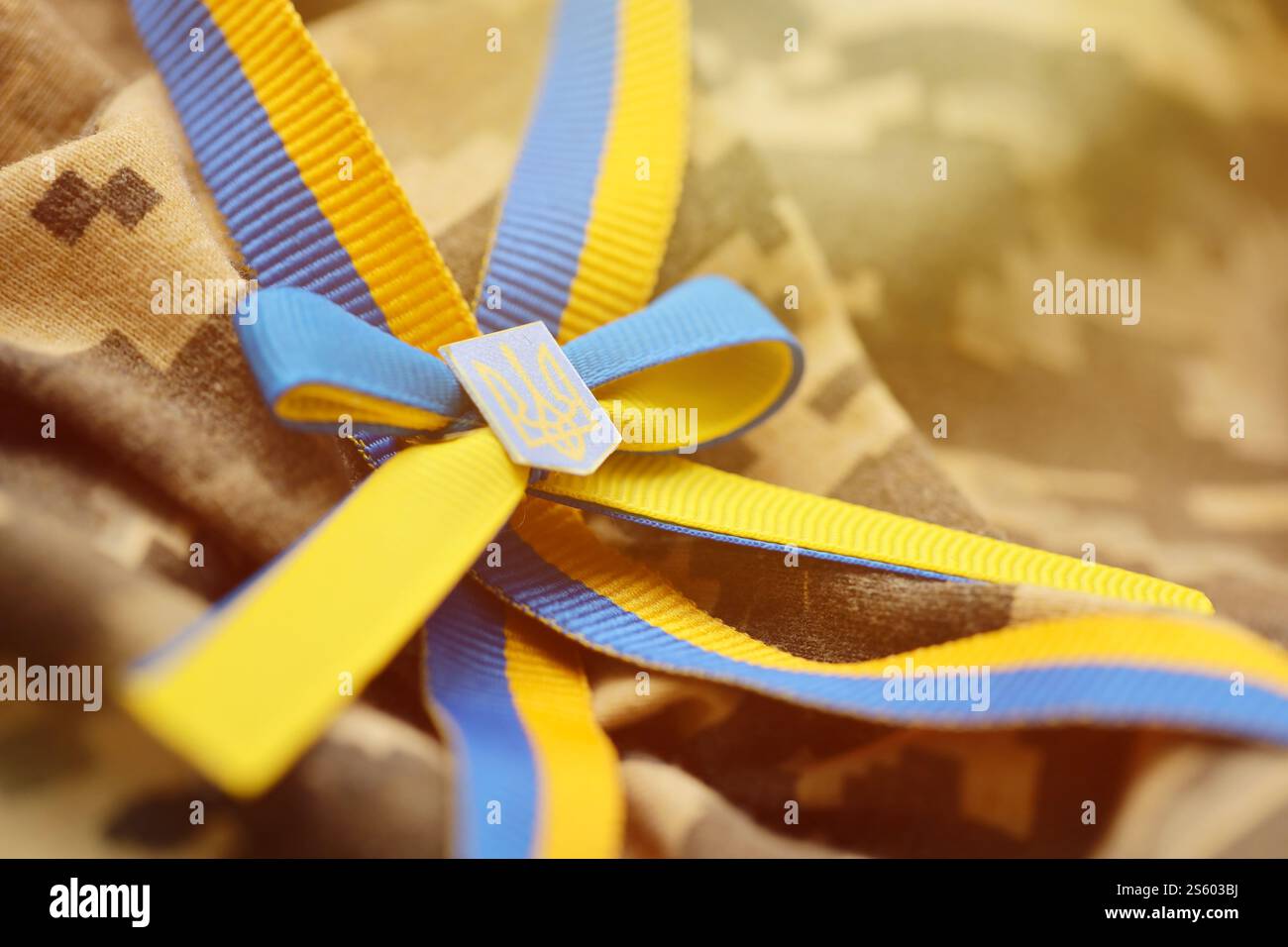 Gepixelter digitaler Militärtarnstoff mit ukrainischer Flagge und Wappen auf Streifenband in blauen und gelben Farben. Attribute von ukrainisch Stockfoto