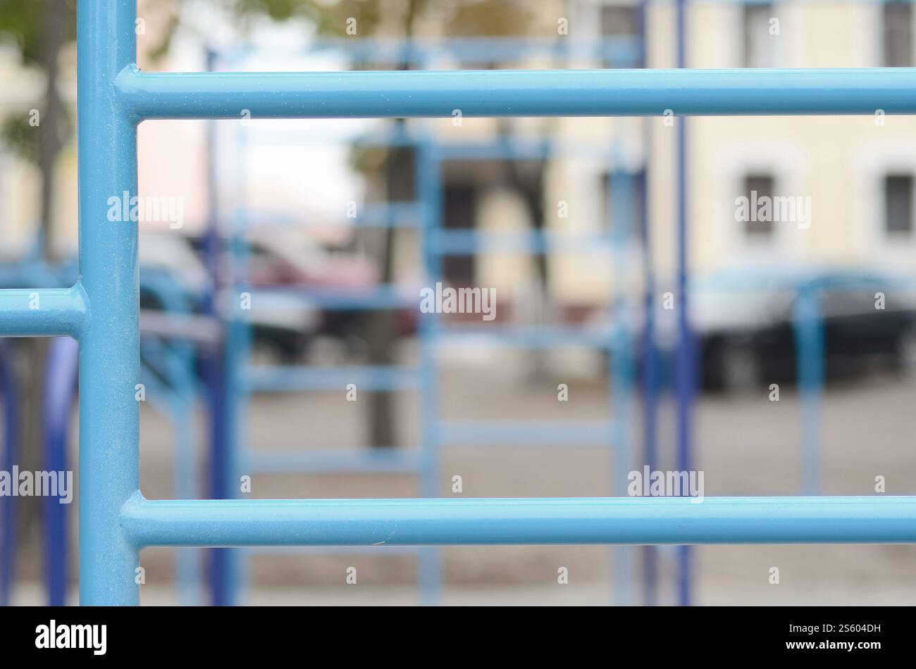 Blaue Metallrohre und Querstangen vor einem Straßensportplatz für Leichtathletik-Training. Sportgeräte im Freien. Makrofoto mit selektiv Stockfoto