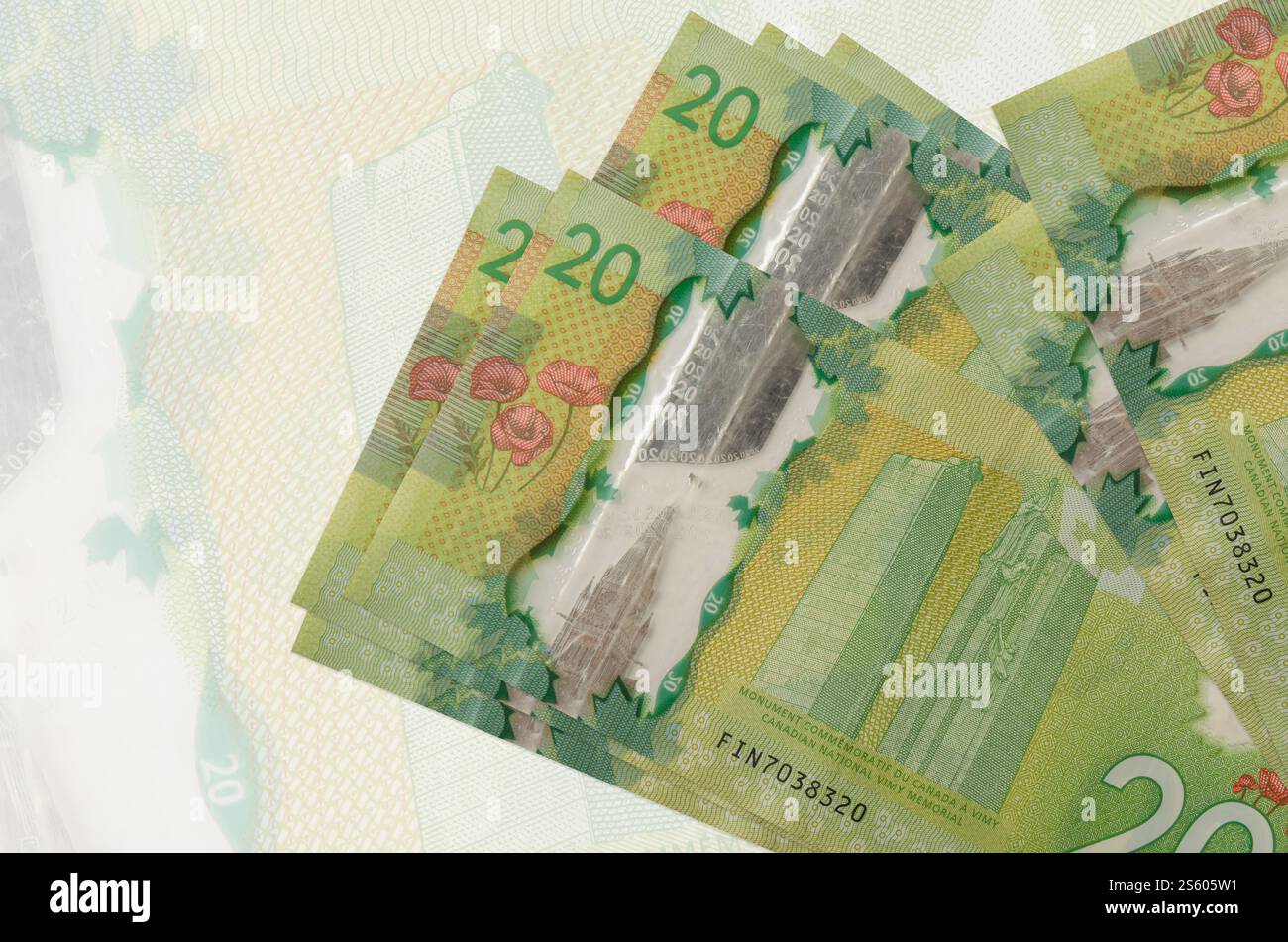 20 kanadische Dollarscheine liegen auf dem Hintergrund großer halbtransparenter Banknoten. Abstrakte Darstellung der Landeswährung. Geschäftskonzept. Stockfoto