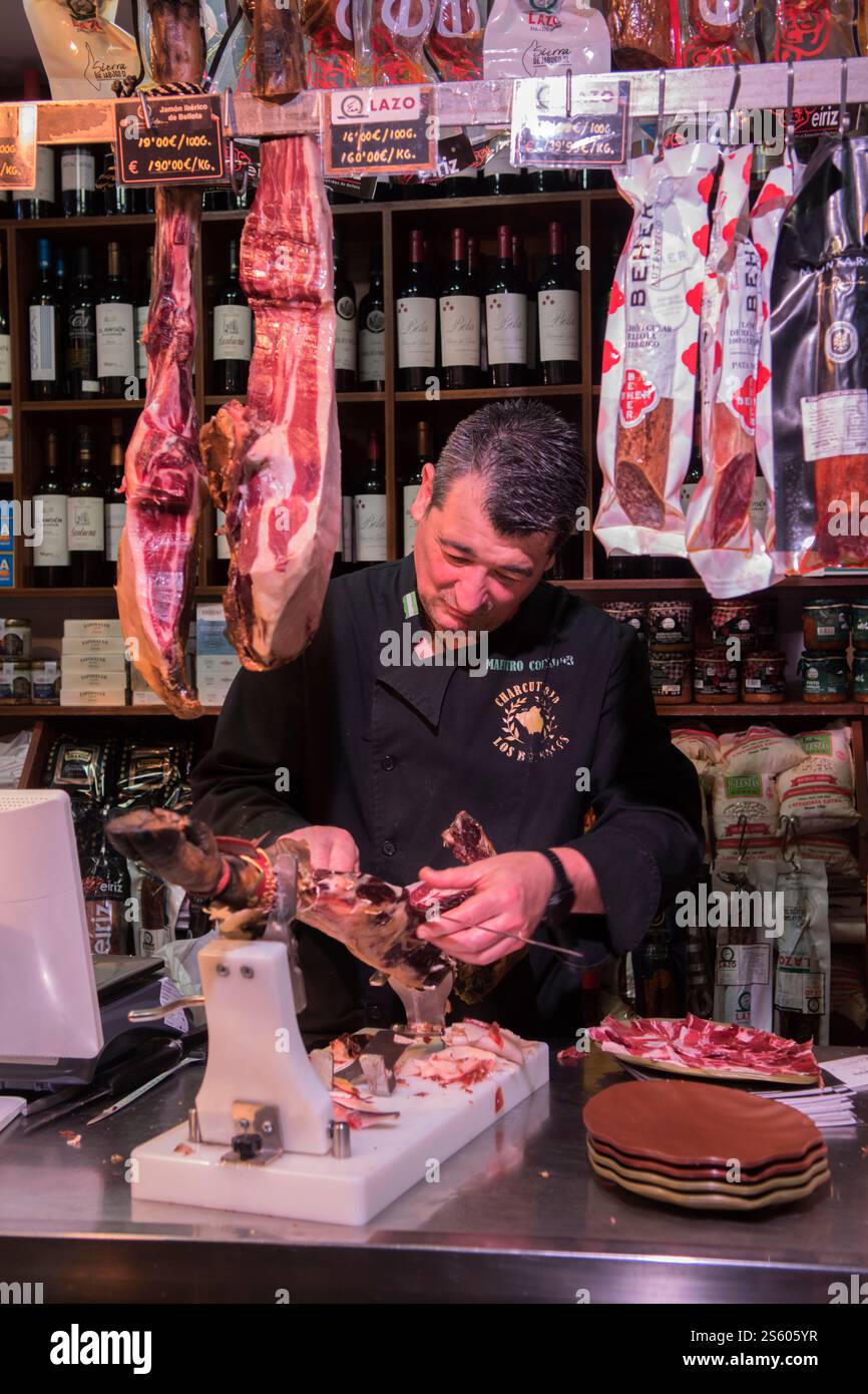 Jamón Serrano - Spanischer Schinken. Mercado de Triana, Triana Local Market Sevilla, ein Marktstand, der Fleisch von einem Schweinefahrer schneidet, um einen Teller Tapas von Jamón Serrano, spanischer Schinken, zu machen - Teller Tapas rechts im Bild. Spanien, Europa 2020er 2025 HOMER SYKES Stockfoto