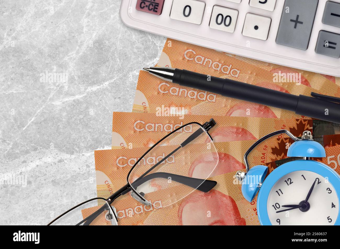 50 kanadische Dollarscheine und Taschenrechner mit Brille und Stift. Geschäftsdarlehen oder Steuerzahlung Saisonkonzept. Finanzplanung und Zeit für die Zahlung von Steuern. Stockfoto