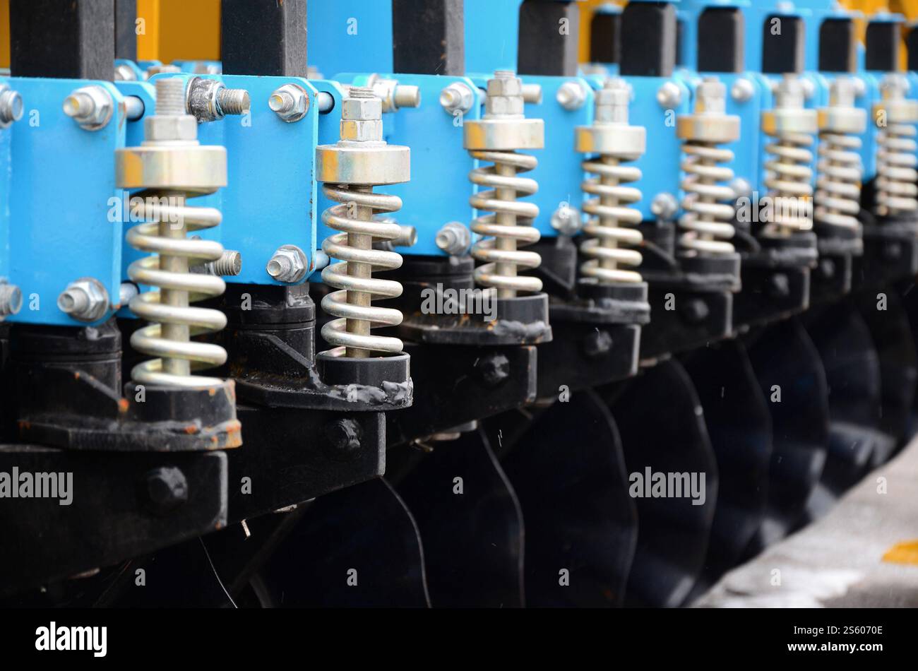 Federsystem der landwirtschaftlichen Sämaschine Nahaufnahme. Federsystem der landwirtschaftlichen Sämaschine im Außenbereich Stockfoto