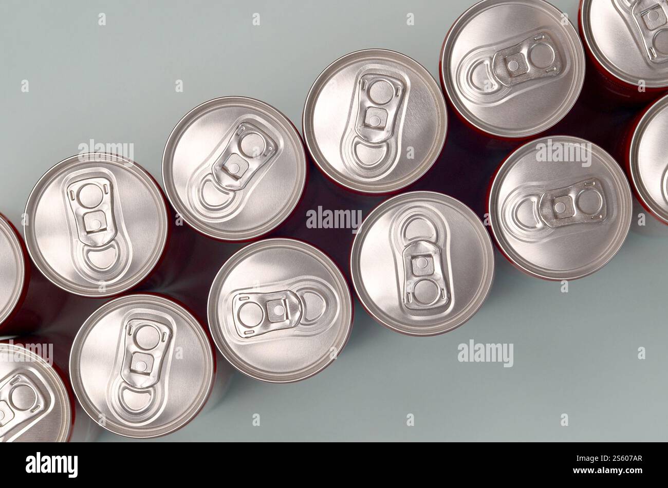 Viele neue Aluminiumdosen mit alkoholfreien Limonaden, Limonade Cola, Bier oder Energy Drink. Konzept der Getränkeherstellung und Massenproduktion. Viele Stockfoto