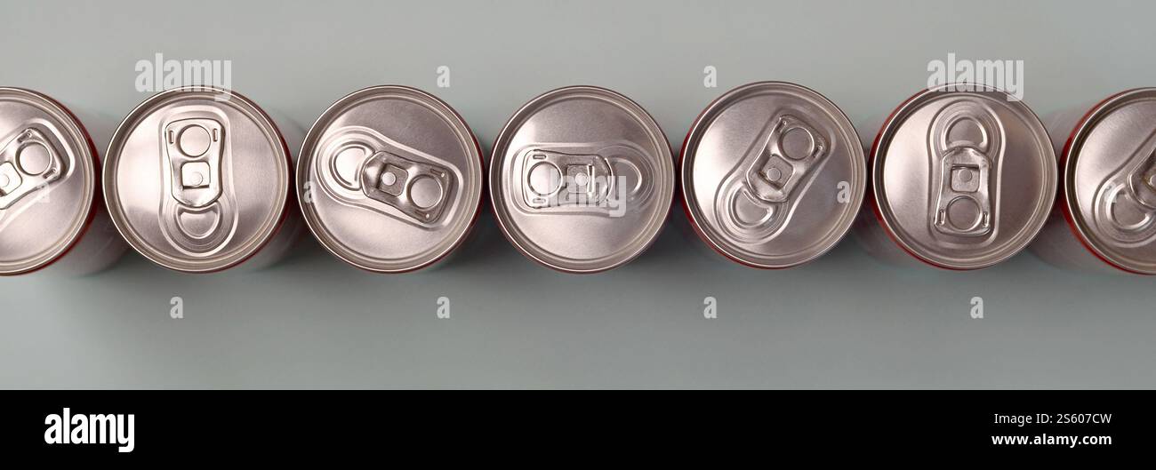 Viele neue Aluminiumdosen mit alkoholfreien Limonaden, Limonade Cola, Bier oder Energy Drink. Konzept der Getränkeherstellung und Massenproduktion. Viele Stockfoto