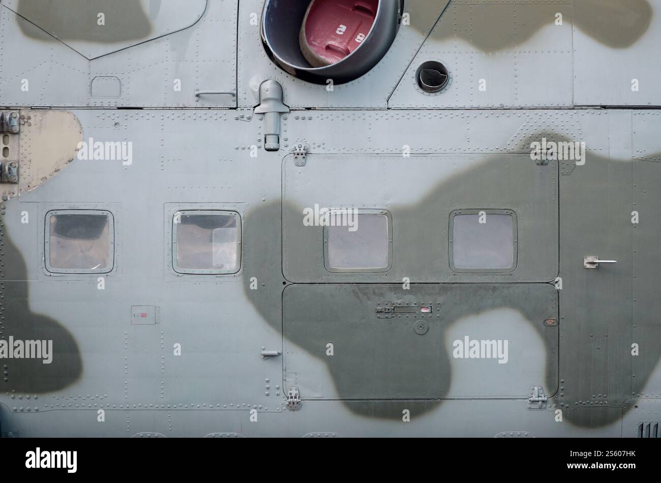 Seitenteile eines Militärhubschraubers in Tarnfarbe. Alte gepanzerte Flugzeuge aus der Nähe. Seitenteile Textur des Militärhubschraubers eingestrichen Stockfoto