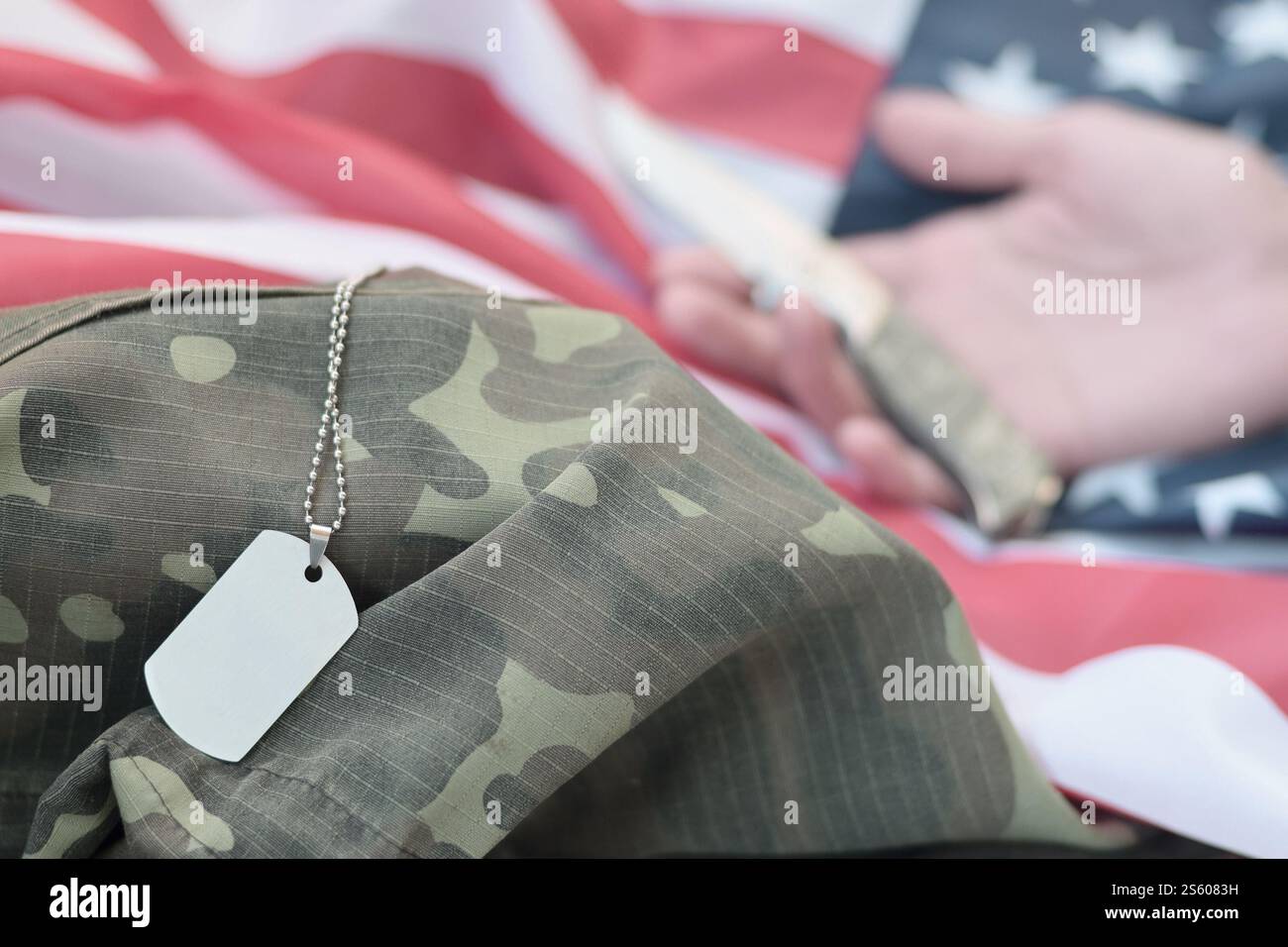 Hundemarken liegen bei der Hand eines Menschen, der Selbstmord mit einem Messer begeht. Das Konzept eines Veteranen, der den Schmerz nicht länger ertragen kann, beschließt, sich umzubringen. Hund Stockfoto