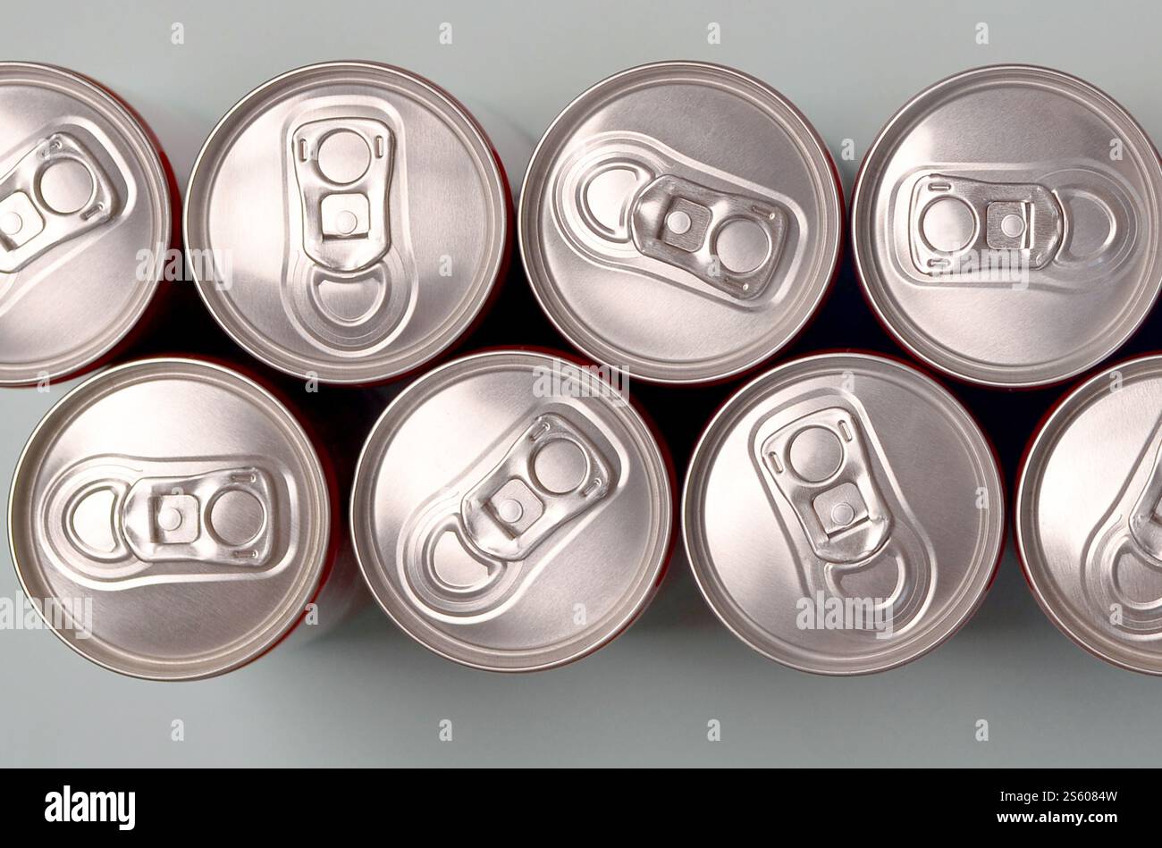 Viele neue Aluminiumdosen mit alkoholfreien Limonaden, Limonade Cola, Bier oder Energy Drink. Konzept der Getränkeherstellung und Massenproduktion. Viele Stockfoto