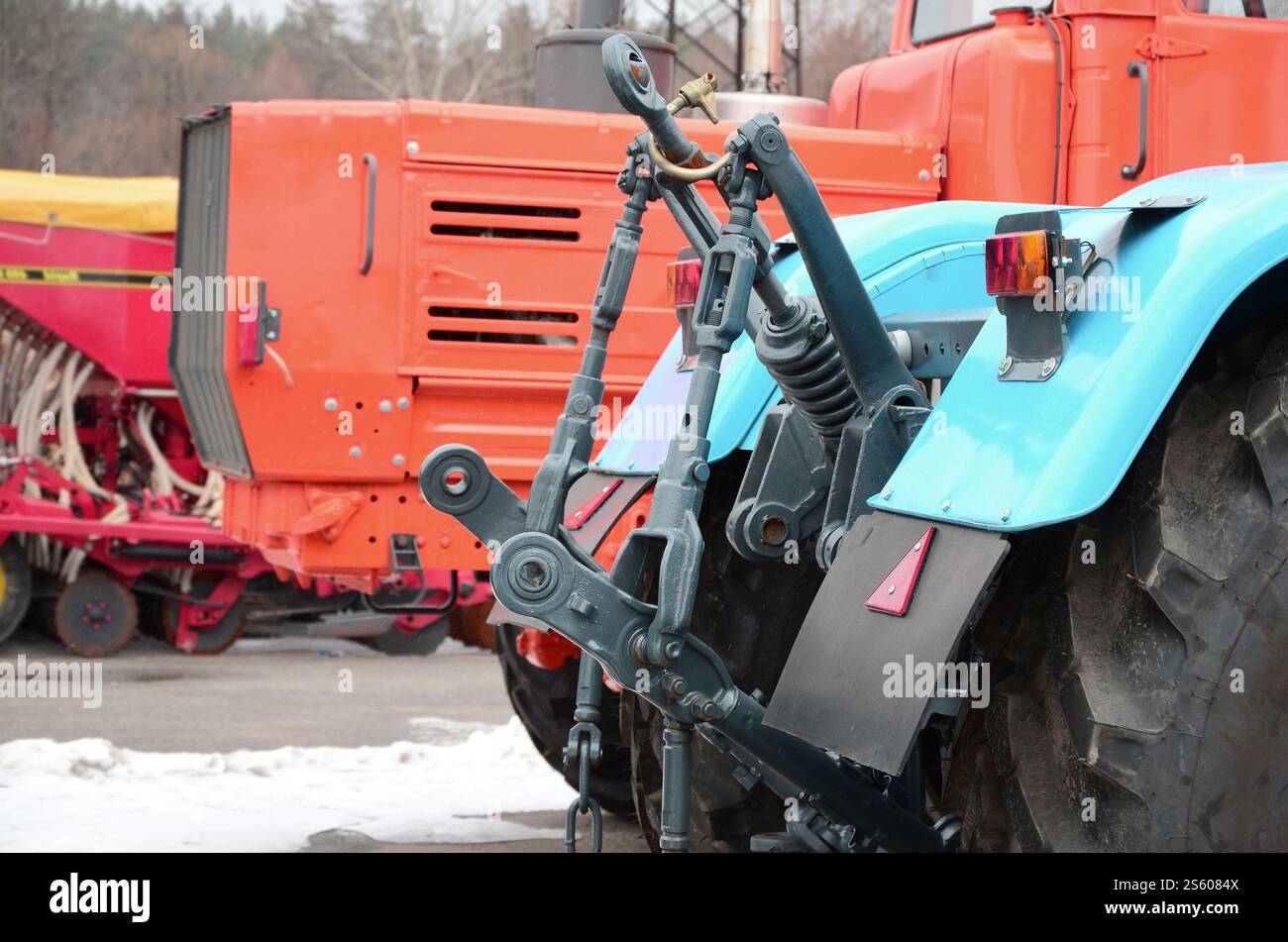 Räder der Rückansicht des neuen Traktors bei Schnee. Rückansicht des landwirtschaftlichen Fahrzeugs. Räder der Rückansicht des neuen Traktors bei Schnee. Stockfoto