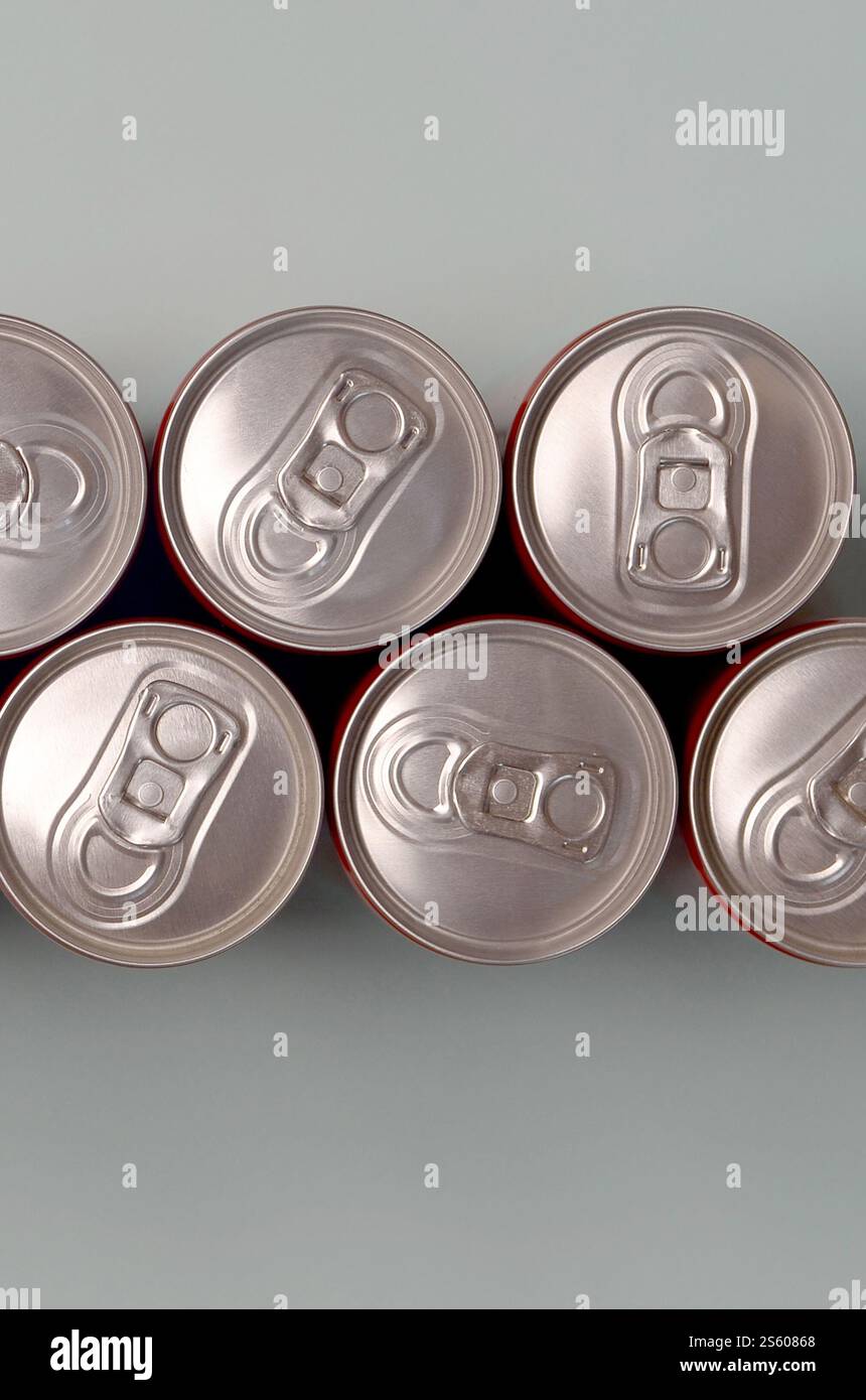 Viele neue Aluminiumdosen mit alkoholfreien Limonaden, Limonade Cola, Bier oder Energy Drink. Konzept der Getränkeherstellung und Massenproduktion. Viele Stockfoto