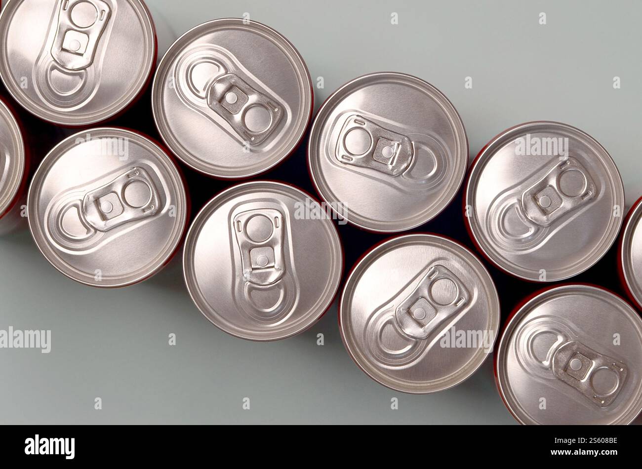Viele neue Aluminiumdosen mit alkoholfreien Limonaden, Limonade Cola, Bier oder Energy Drink. Konzept der Getränkeherstellung und Massenproduktion. Viele Stockfoto