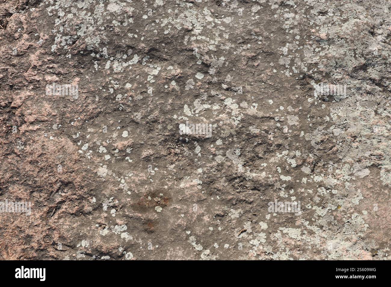 Nahaufnahme der Rohsteinstruktur einer grossen Gesteinsoberfläche für natürliche Hintergrundkonzepte. Großaufnahme schmutzige Naturstein Hintergrund Textur in warm Stockfoto