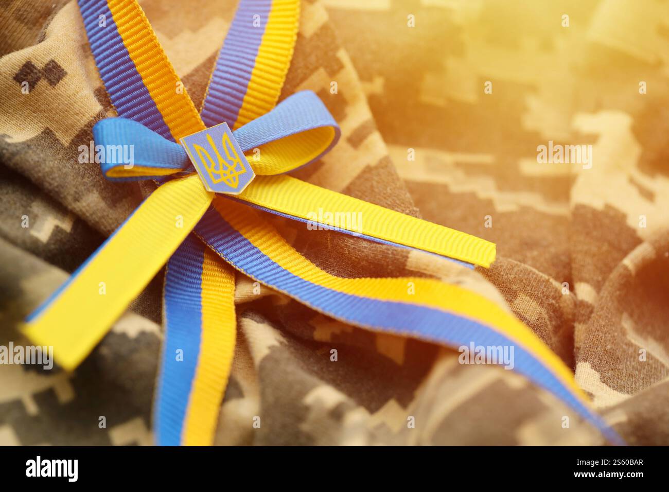 Gepixelter digitaler Militärtarnstoff mit ukrainischer Flagge und Wappen auf Streifenband in blauen und gelben Farben. Attribute von ukrainisch Stockfoto