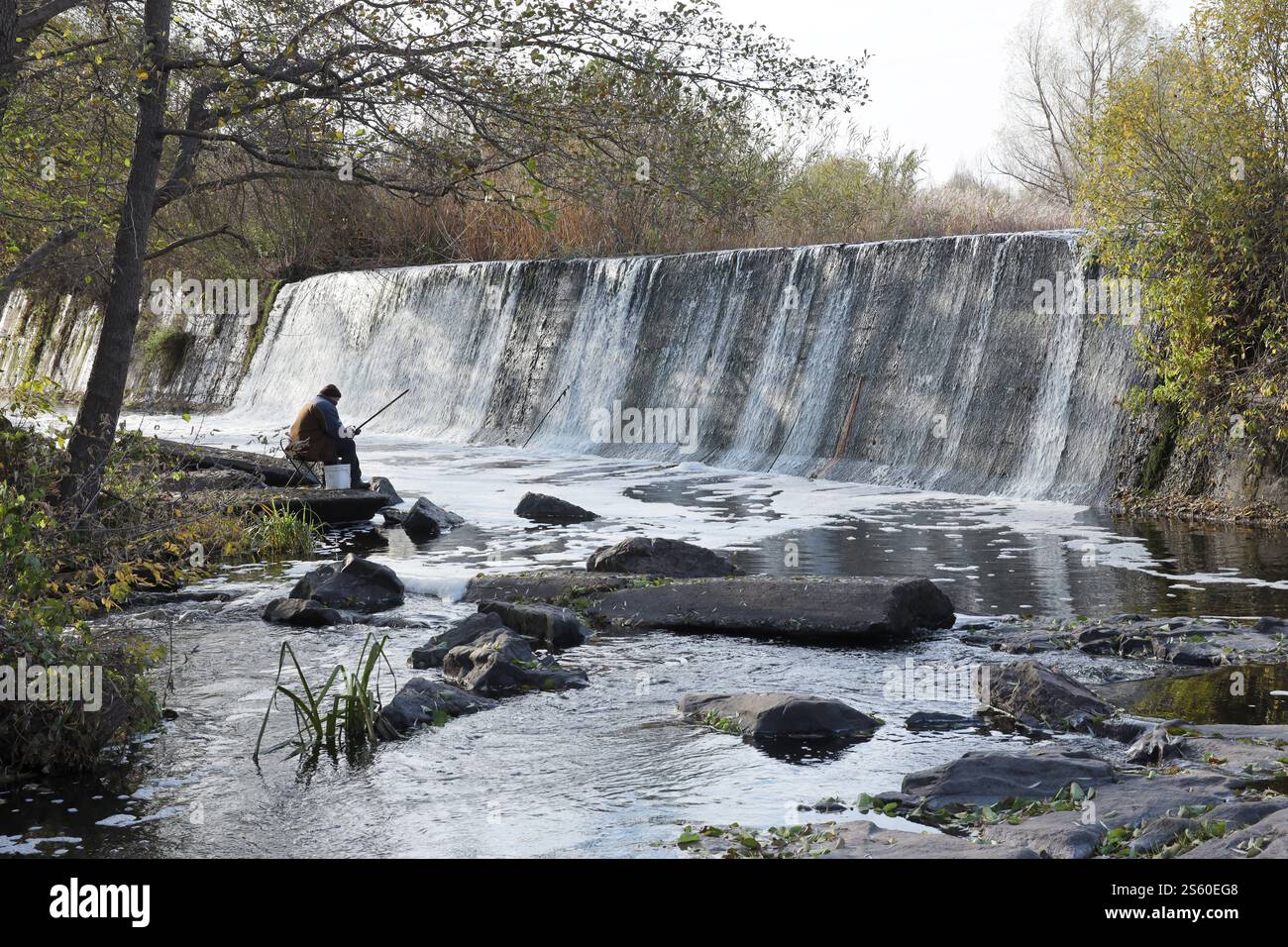 Ein stillgelegter Damm, ein künstlicher Wasserfall, der Damm der Butka HPP, befindet sich am Fluss hinter der Brücke über den Hirsky Tikich. Ein Stockfoto