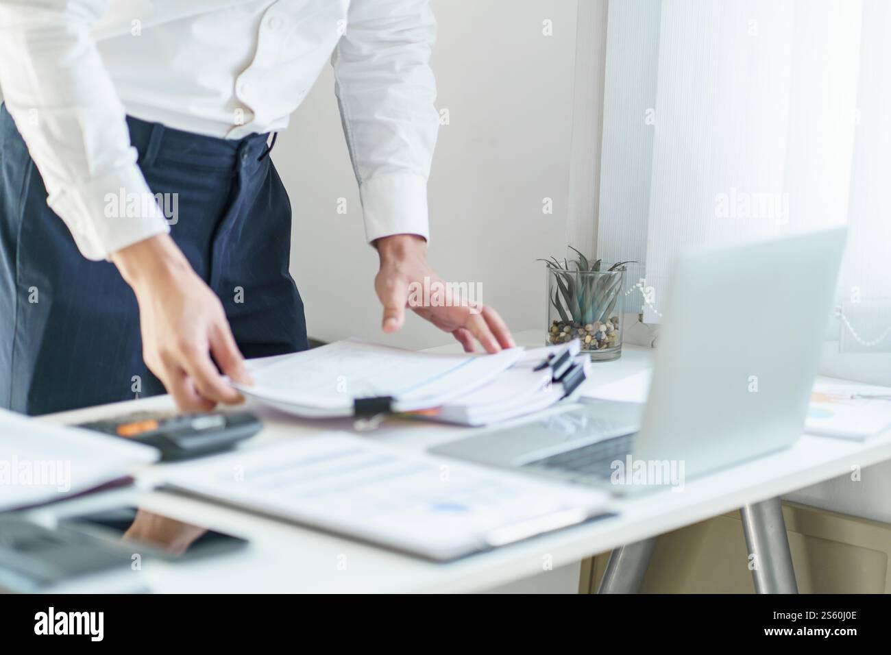 Junger Geschäftsmann, der im Büro arbeitet. Geschäftsmann, der Finanzpapierarbeiten macht, Unternehmensmanagement-Konzept. Stockfoto